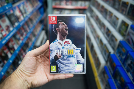 Bratislava, Slovakia, december 2, 2017: Man holding Fifa 18 videogame on Nintendo Switch console in storeのeditorial素材
