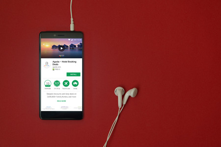Los Angeles, January 11, 2018: Smartphone with Agoda hotel booking application in google play store...