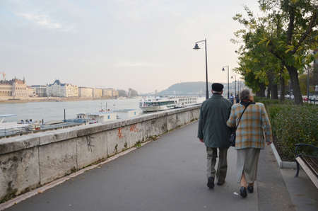 Back view of old couple walking together. Budapest, Hungaryâs capital, is bisected by the River Danube.のeditorial素材