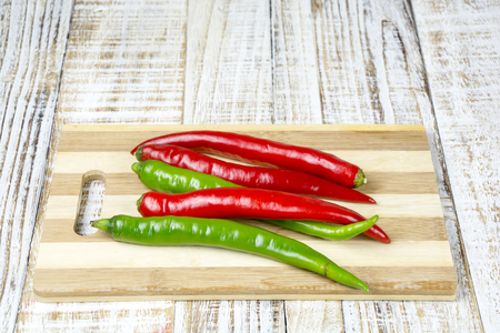 Green and Red chili pepper isolated on a wood backgroundの写真素材