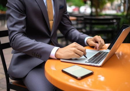 closeup with hand of businessman using laptop, with out door cafe, chilling, technology concept.の素材