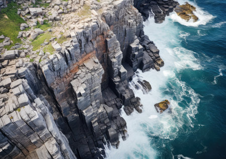 Aerial view of rocky coastline. Waves hitting in rocks. Birds eye view of the sea, cinimatic sea and moutain view.の素材