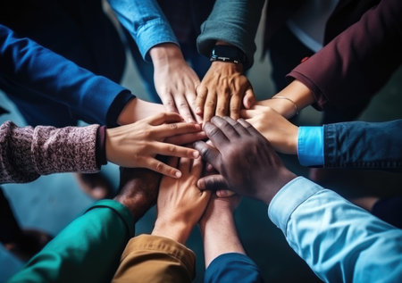Diverse business people group put hands together in stack pile at training as concept of sales team corporate unity connection, teambuilding loyalty, support in teamwork, coaching, close up top view.の素材