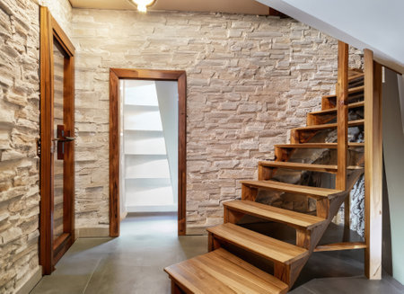 Wooden staircase and stone cladding wall in rustic hallway . Cozy home interior designの素材