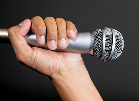 hand with microphone on gray background, close oの素材