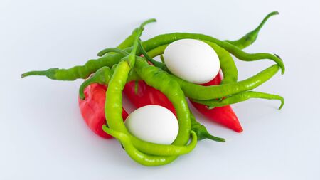 Organic and natural eggs, red and green peppers on white backgroundの写真素材