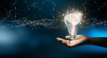 Businessman holding Light bulbs with Brain inside and Low poly wireframe outside. Creative and innovation inspiration. Business Bright idea concept.の写真素材