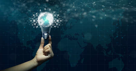 Businessman hand holding global network connected in Light bulb on abstract technology background. Innovation idea with Global communication network and Business community concept.の写真素材