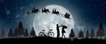 Silhouette of Santa Claus get a move to ride on their reindeer over full moon at night Christmas. Enjoying couple dancing under the full moon.の写真素材