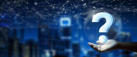 Man hand holding digital question mark holographic. Double Exposure of Night City background. Q and A discussion. FAQ, Support, Question and Answer. Help service business Concept.の写真素材