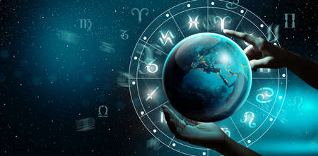 Astrological zodiac signs inside of horoscope with planet Earth in hand. Knowledge of the stars in the sky. The power of the universe concept.の写真素材