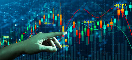 Double exposure of Business man hand on digital stock market financial indicator with night city background. Abstract financial trading graphs and Stock analyzing. Trading and investment concept.の写真素材