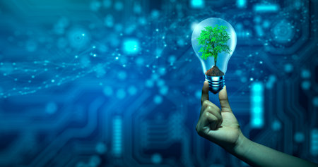 Hand holding Tree growing in light bulb. Ecology and Technology Convergence. Green Computing, Green Technology, Green IT, csr, and IT ethics Concept.の写真素材