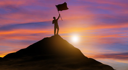 Silhouette businessman with flag climbed to the top of mountain over the sky and sun light...