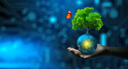 Man hand holding Tree on digital ball with technological convergence blue background. Green computing, csr, IT ethics, Nature technology interaction, and Environmental friendly.の写真素材