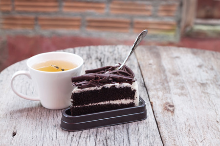 Hot tea and Chocolate cake on wood tableの写真素材