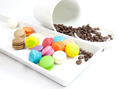 Coffee bean and mini macaroon colorful in white caramic plate on white backgroundの写真素材