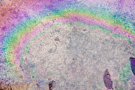 Oil on ground when wet cause rainbow on water on ground concreteの写真素材