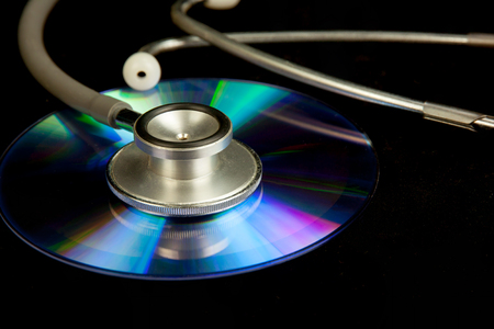 Disk CD and stethoscope on black backgroundの写真素材