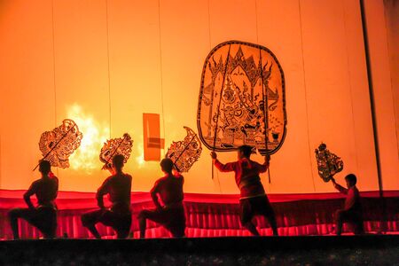 RATCHABURI THAILAND - APRIL 14, 2015: The Cowskin shows a man holding a stencil pattern. Moving Cowskin the light to shadow play. The musical atmosphere and read a poem composed. In a traditional culture. There are performances every year Thailand in SONGのeditorial素材
