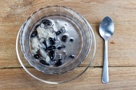 Sweet Sticky Rice and Black Beans in Coconut Milk. Thai dessert on wood tableの写真素材