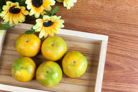 Ripe fruit orange in wooden tray on wood tableの写真素材