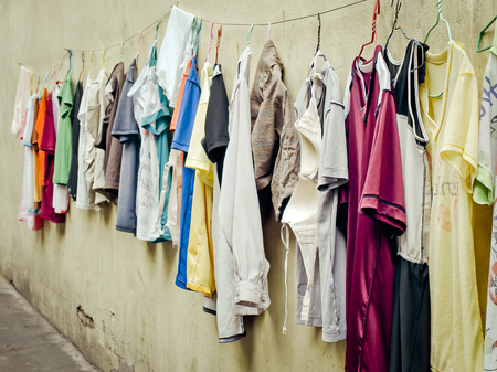 Old clothes hangers and colorful clothes in the sunlight, Selective focus