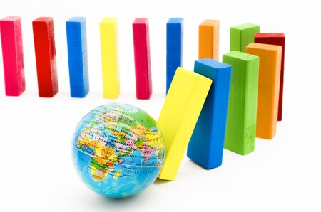 The domino effect of globe and colorful wooden blocks on white background, Selective focus