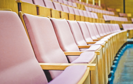 Close up and selective focus of Empty rows of armchairs in hall/ Color effect image
