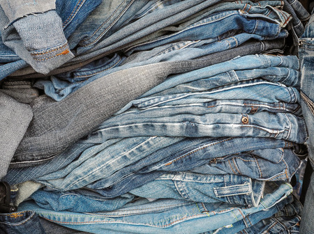 Pile of jeans of various shades, Background fashion jeansの写真素材
