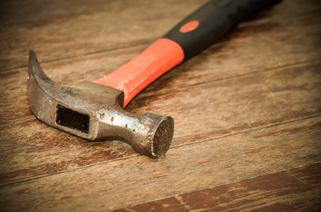 Old red hammer on wood background, With place for your textの写真素材