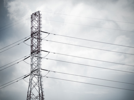 High voltage tower and cable line with black rain clouds/ Concept imageの写真素材