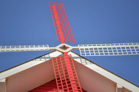 Close up of red and white windmill with blue skyの写真素材