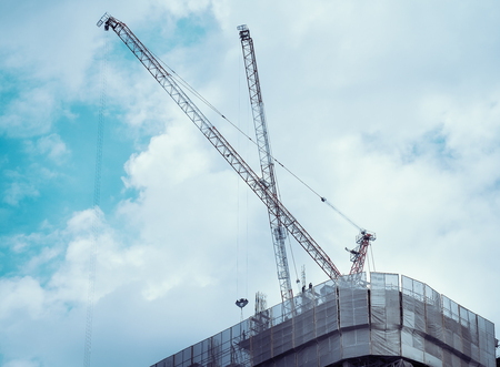 Construction tower canes over construction site.