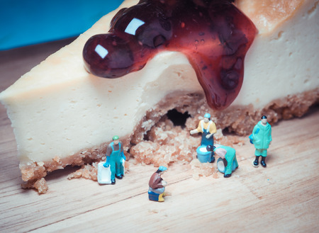 Miniature people: Gardeners are helping to keep the blueberry cheesecake.の写真素材