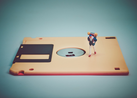 Miniature people: Travelers walk on the old diskette. Retro filter colorの写真素材