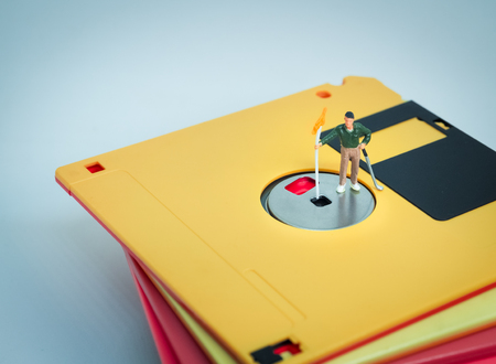 Miniature people: Golfer stand on the diskette. Retro filter colorの写真素材