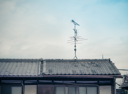 Old analog antenna for TV with blue sky background. Vintage color fitter with place your text. Kyoto, Japan.の写真素材
