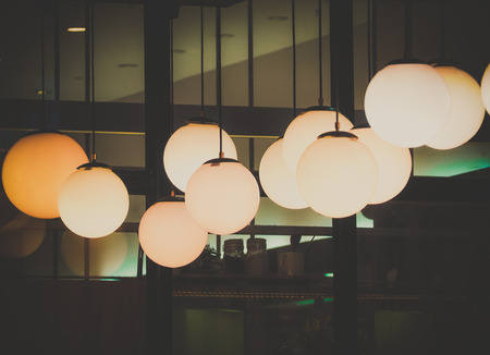 Lighting ball hanging from the ceiling on the black backgroundの写真素材