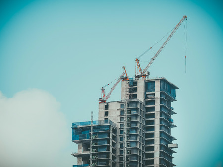 Construction tower cranes over construction site. Building development.