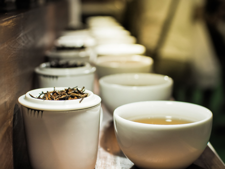 White tea pot and cups with the black tea leaves, Close up image.の写真素材