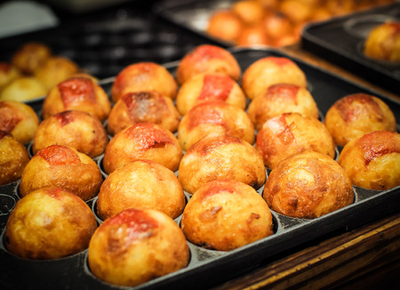 Takoyaki are cooked on the hot stove. Japanese appetizersの写真素材