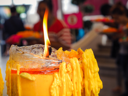 Yellow candle burning in old church. Flaming candle.の写真素材