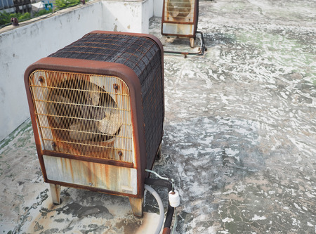 Rusty heavy duty industrial size air compressor machine units on roof deck.の写真素材