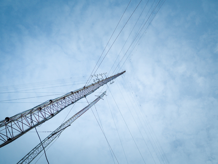 High radio wave transmission towers against a blue sky.