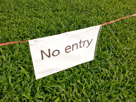 No entry sign on white paper in the green feild or playground.