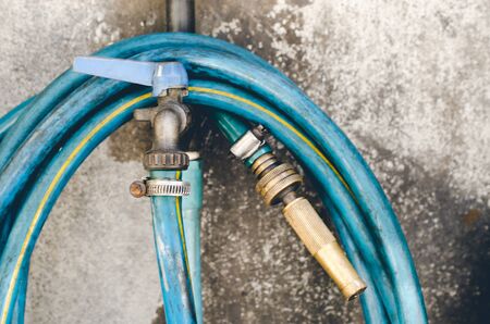 Old hose trolley mounted on a concrete wall. Tool and equipment for gardening.の写真素材