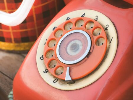 Close up of old retro red phone keypad. Analog dial pad of old phone. Vintage and retro telephone.