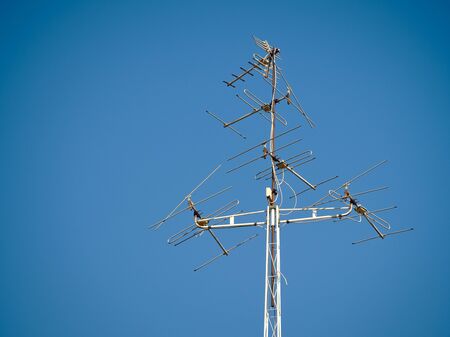Old television antenna signal transmission on sky blue. Old technology TV communication.の写真素材