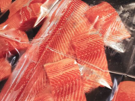 Fresh salmon fillets placed on display for sale. Salmon fillets covered with clear plastic to block the infection during the epidemic situation.の写真素材